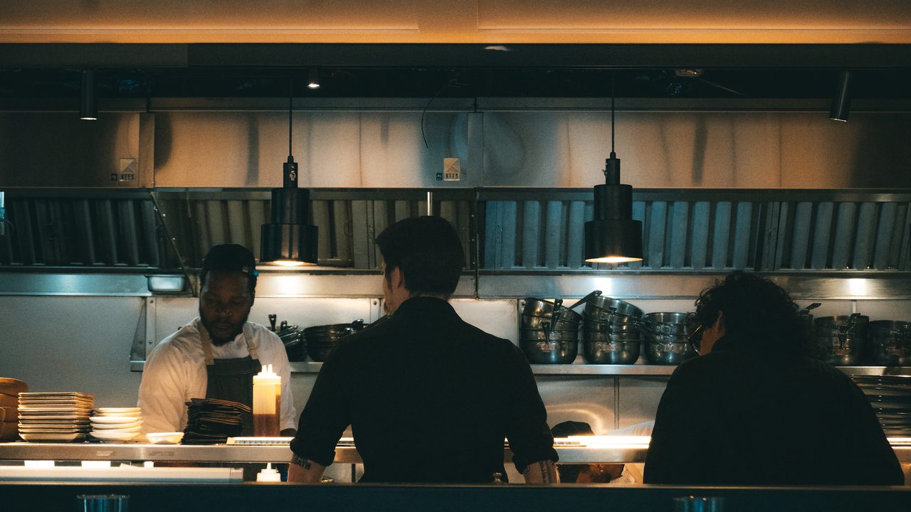 Chefs plating dishes in a restaurant kitchen during a promo shoot